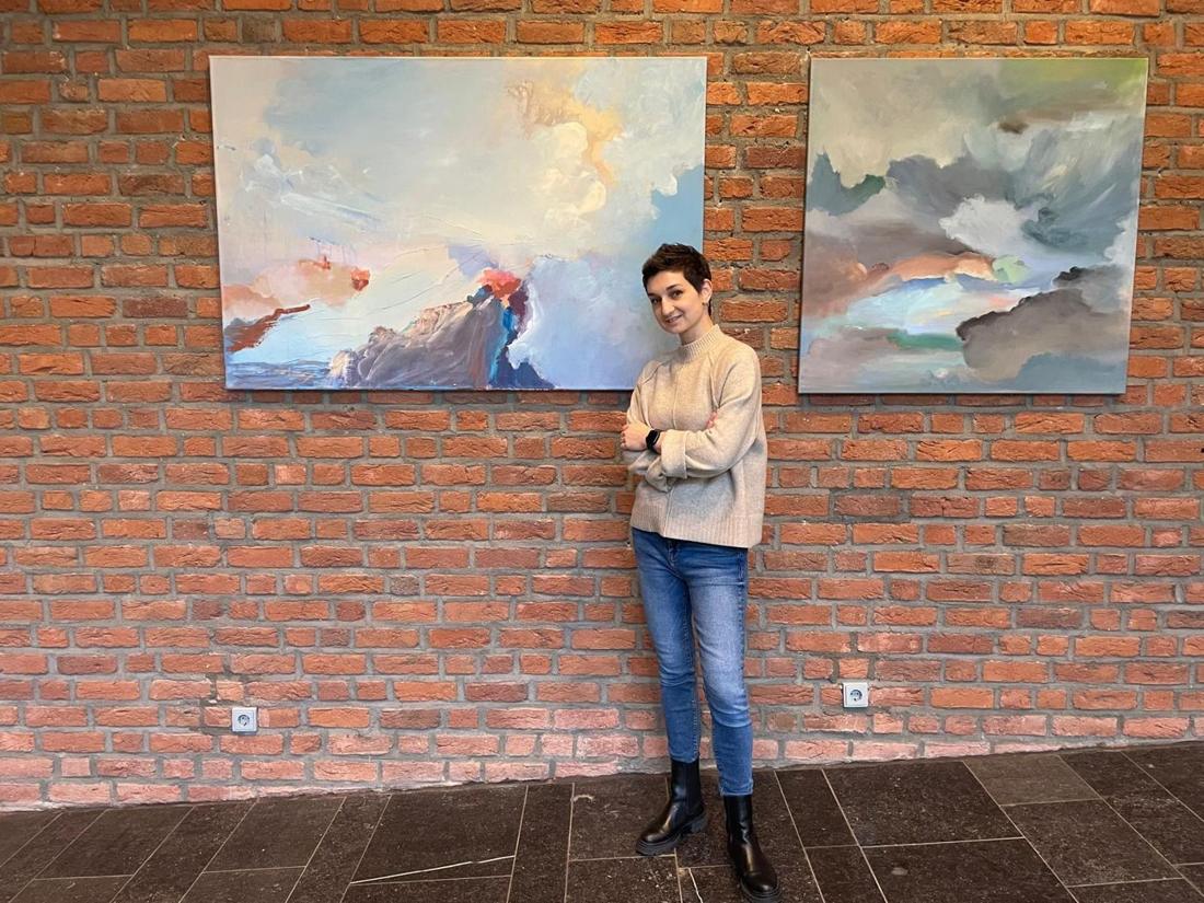 Sinilha Lastivka vor zwei ihrer Gemälde